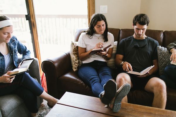 Four Missionaries Sitting and Reading the Bible