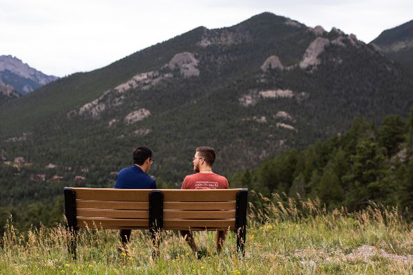 Two Male Students Sitting on a Bench in Estes Park
